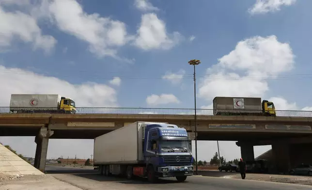 A convoy of vehicles, above, loaded with food and other aid is en route to Sweida on the international highway in rural Daraa province, Syria, Sunday, July 20, 2025, heading to the city of Busra al-Sham. (AP Photo/Omar Sanadiki)