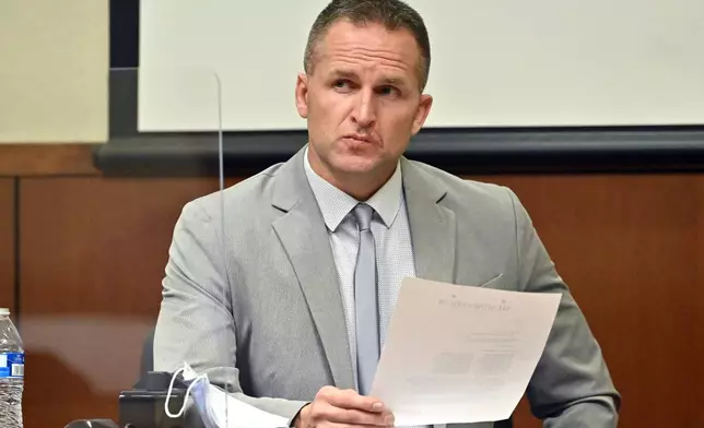 FILE - Former Louisville Police officer Brett Hankison examines a document as he answers questions from the prosecution, March 2, 2022, in Louisville, Ky. (AP Photo/Timothy D. Easley, Pool, File)