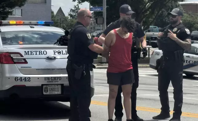 In this photo provided by WHAS-11 News, a protestor is seen detained by police outside the federal courthouse where ex-Kentucky police officer Brett Hankison, convicted of using excessive force during the deadly Breonna Taylor raid, is taking place, Monday, July 21, 2025, in Louisville, Ky. (Alyssa Newton/WHAS-11 News via AP)