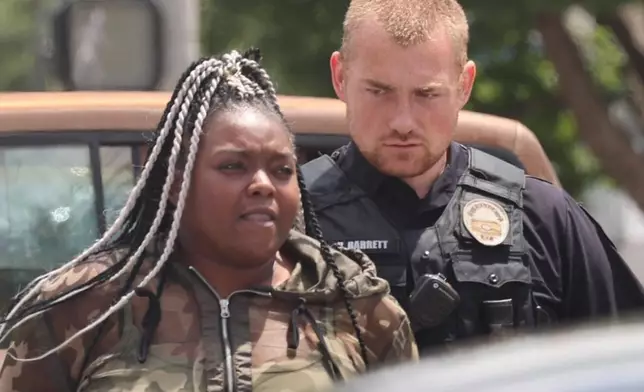 In this photo provided by WHAS-11 News, Breonna Taylor's aunt Bianca Austin is detained by police outside the federal courthouse where ex-Kentucky police officer Brett Hankison, convicted of using excessive force during the deadly Breonna Taylor raid, is taking place, Monday, July 21, 2025, in Louisville, Ky. (Alyssa Newton/WHAS-11 News via AP)