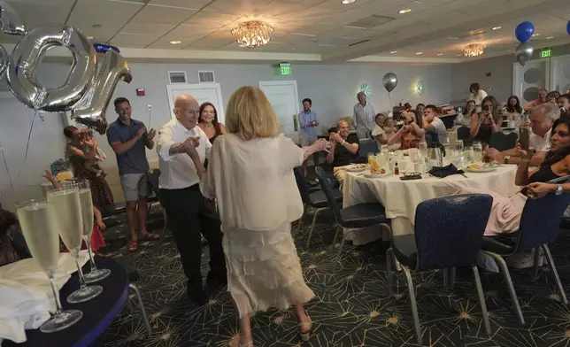 Harold Terens, a World War II veteran who fought in D-Day, dances with his wife Jeanne Swerlin during his 102 birthday party Saturday, July 26, 2025, in Delray Beach, Fla. (AP Photo/Marta Lavandier)