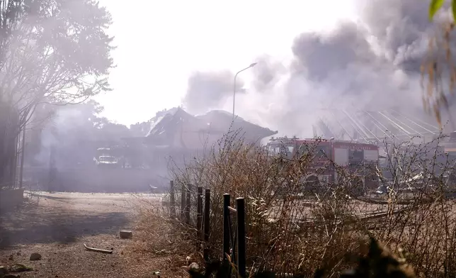 Firefighters work as smoke rises after a gas station exploded on the outskirts of Rome, Friday, July 4, 2025. (Cecilia Fabiano/LaPresse via AP)