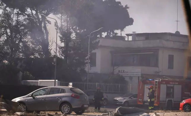 Firefighters work as smoke rises after a gas station exploded on the outskirts of Rome, Friday, July 4, 2025. (Cecilia Fabiano/LaPresse via AP)
