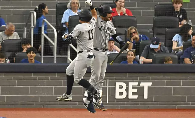 New York Yankees' Anthony Volpe (11) and Oswald Peraza, right, celebrate Volpe's solo home run against the Toronto Blue Jays in the fifth inning of a baseball game in Toronto on Wednesday, July 23, 2025. (Jon Blacker/The Canadian Press via AP)