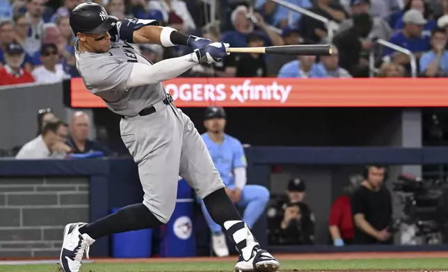 New York Yankees' Aaron Judge (99) hits a two-run home run against the Toronto Blue Jays in the sixth inning of a baseball game in Toronto on Wednesday, July 23, 2025. (Jon Blacker/The Canadian Press via AP)