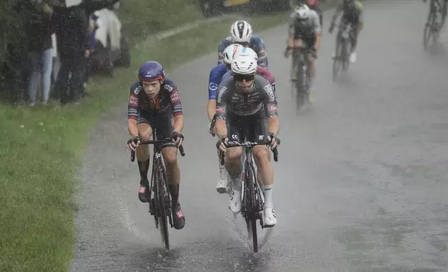 Stage winner Australia's Kaden Groves, center front, and Netherlands' Frank van den Broek, ride in the breakaway in a downpour during the twentieth stage of the Tour de France cycling race over 184.2 kilometers (114.5 miles) with start in Nantua and finish in Pontarlier, France, Saturday, July 26, 2025. (AP Photo/Thibault Camus)
