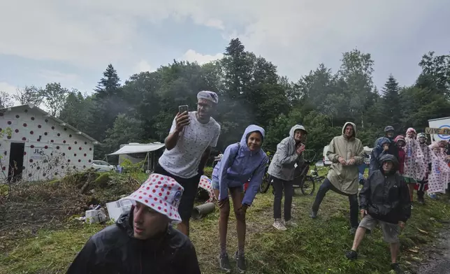 Spectators wait for the riders to pass during the twentieth stage of the Tour de France cycling race over 184.2 kilometers (114.5 miles) with start in Nantua and finish in Pontarlier, France, Saturday, July 26, 2025. (AP Photo/Thibault Camus)