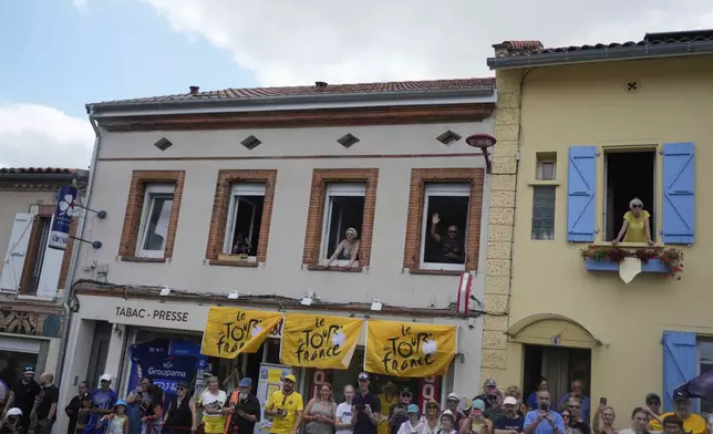 Spectators wait for the riders to pass during the fifteenth stage of the Tour de France cycling race over 169.3 kilometers (105.2 miles) with start in Muret and finish in Carcassone, France, Sunday, July 20, 2025. (AP Photo/Mosa'ab Elshamy)