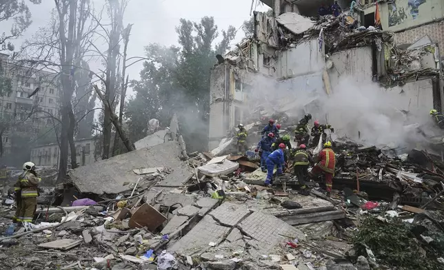 Rescuers work in a destroyed apartment building after a Russian missile attack in Kyiv, Ukraine, Thursday, July 31, 2025. (AP Photo/Efrem Lukatsky)