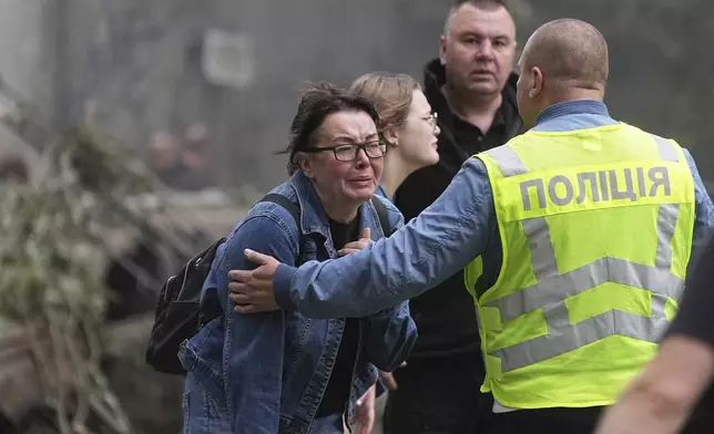 Women react outside a destroyed apartment building after a Russian missile attack in Kyiv, Ukraine, Thursday, July 31, 2025. (AP Photo/Efrem Lukatsky)