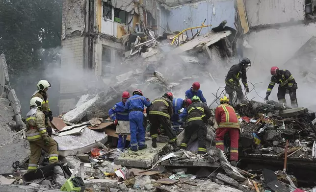 Rescuers work in a destroyed apartment building after a Russian missile attack in Kyiv, Ukraine, Thursday, July 31, 2025. (AP Photo/Efrem Lukatsky)