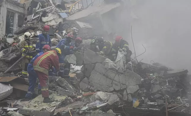 Rescuers work in a destroyed apartment building after a Russian missile attack in Kyiv, Ukraine, Thursday, July 31, 2025. (AP Photo/Efrem Lukatsky)