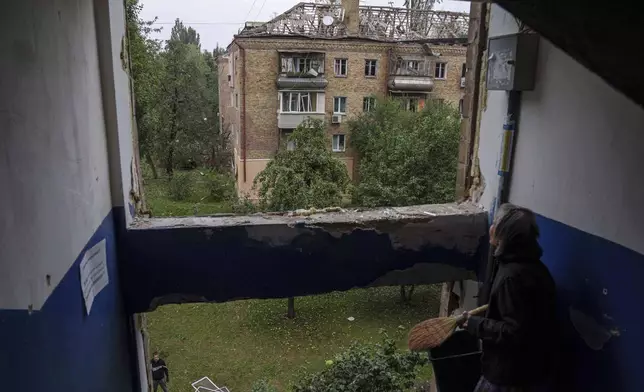 A local woman looks at a residential building heavily damaged by a Russian strike in Kyiv, Ukraine, on Thursday, July 31, 2025. (AP Photo/Evgeniy Maloletka)