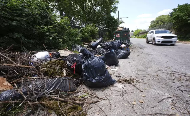 A car drives past a garbage collection site, Wednesday, July 9, 2025, in Philadelphia. (AP Photo/Matt Slocum)