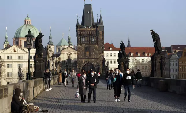 FILE - People across the medieval Charles Bridge in Prague, Czech Republic, Feb. 25, 2021. (AP Photo/Petr David Josek, File)