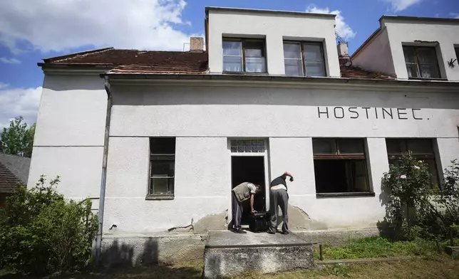 Residents try to start a generator as Czech Republic faces a major electricity blackout near Benesov, Czech Republic, Friday, July 4, 2025. (AP Photo/Petr David Josek)
