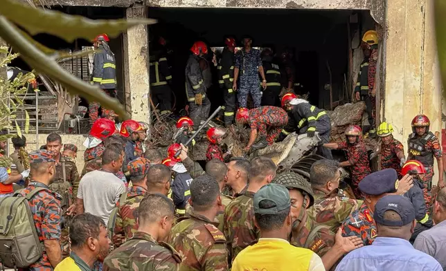 Firemen check the wreckage of a Bangladesh Air Force training aircraft that crashed onto a school campus in Dhaka, Bangladesh, Monday, July 21, 2025. (AP Photo/Al-emrun Garjon)