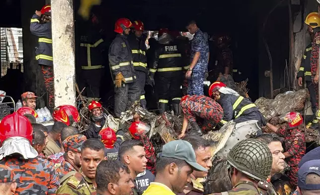 Firemen check the wreckage of a Bangladesh Air Force training aircraft that crashed onto a school campus in Dhaka, Bangladesh, Monday, July 21, 2025. (AP Photo/Al-emrun Garjon)