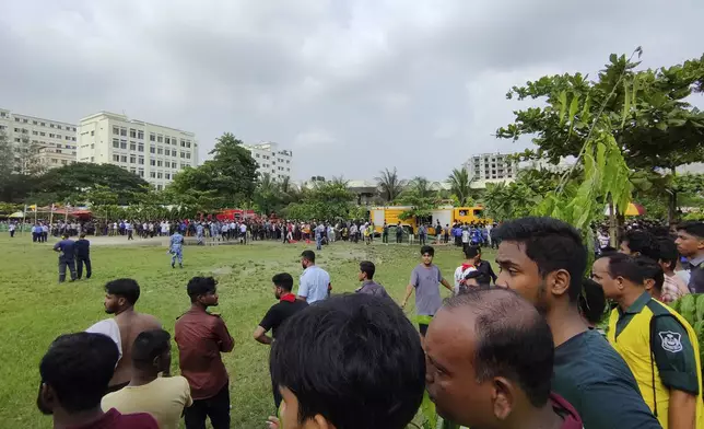 Volunteers cordon off the area after a Bangladesh Air Force training aircraft has crashed onto a school campus in Dhaka, Bangladesh, Monday, July 21, 2025. (AP Photo/Mahmud Hossain Opu)