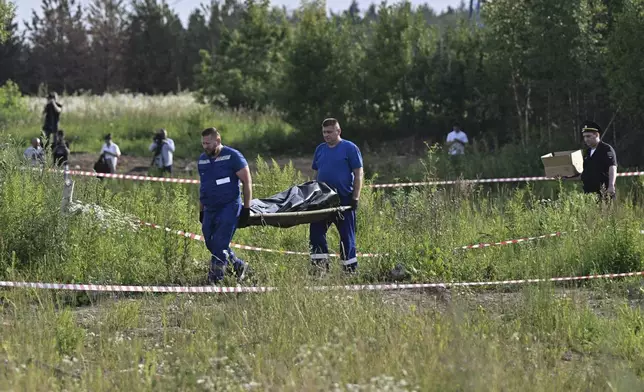 Russian law enforcement agents carry the body of former Transportation Minister Roman Starovoit, who was found dead from a gunshot wound in an apparent suicide, investigators said Monday, hours after his dismissal in Odintsovo, outside Moscow, Russia, Monday, July 7, 2025. (Evgeniy Razumniy/Kommersant Photo via AP)