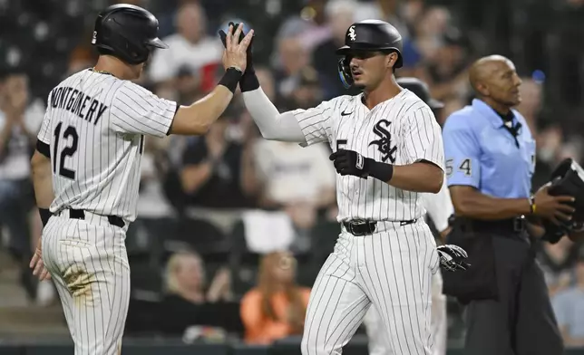 Chicago White Sox's Josh Rojas (5) and Colson Montgomery (12) celebrate at home plate after scoring on a Mike Tauchman single during the seventh inning of a baseball game against the Toronto Blue Jays, Monday, July 7, 2025, in Chicago. (AP Photo/Paul Beaty)