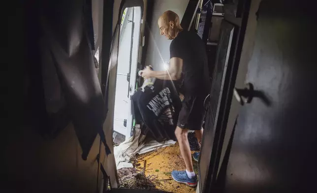 Thomas Rux, a resident of Riverside RV Park, goes through the wreckage of his RV that was swept away by floodwaters in Ingram, Texas, on Friday, July 4, 2025. (Christopher Lee/The San Antonio Express-News via AP)