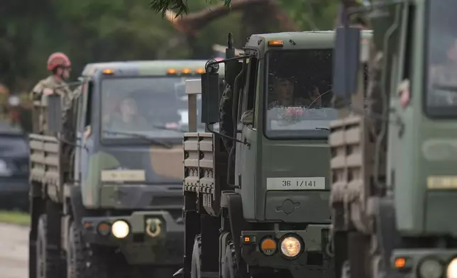 A military convoy drives on a road along the Guadalupe River after a flash flood swept through the area Saturday, July 5, 2025, in Hunt, Texas. (AP Photo/Julio Cortez)