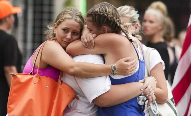 Campers embrace after arriving to a reunification area as girls from Camp Waldemar, near the North fork of the Guadalupe River, are reconnected with their families after heavy rainfall in Central Texas, Saturday, July 5, 2025. (Jason Fochtman/Houston Chronicle via AP)