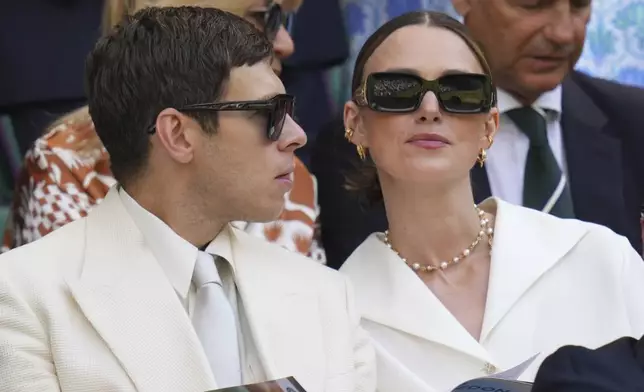 Actor Keira Knightley and James Righton sit in the Royal Box to watch Veronika Kudermetova of Russia and Elise Mertens of Belgium against Jelena Ostapenko of Latvia and Su-Weih Hsieh of Taiwan during the women's doubles final match at the Wimbledon Tennis Championships in London, Sunday, July 13, 2025.(AP Photo/Kirsty Wigglesworth)