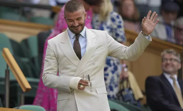 Sir David Beckham waves as he arrives to take his seat in the Royal Box on Centre Court on day one at the Wimbledon Tennis Championships in London, Monday, June 30, 2025. (AP Photo/Alastair Grant)