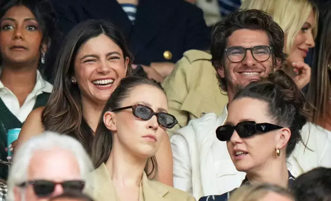Actors Andrew Garfield and Monica Barbaro watch as Sonay Kartal of Britain plays Russia's Anastasia Pavlyuchenkova during a fourth round women's singles match at the Wimbledon Tennis Championships in London, Sunday, July 6, 2025. (AP Photo/Alastair Grant)