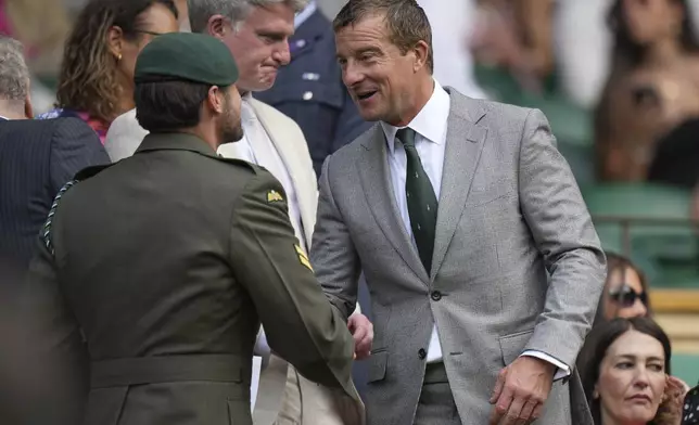 Adventurer and TV presenter Bear Grylls, right, arrives in the Royal Box on day four of the Wimbledon Tennis Championships in London, Thursday, July 3, 2025. (AP Photo/Alastair Grant)
