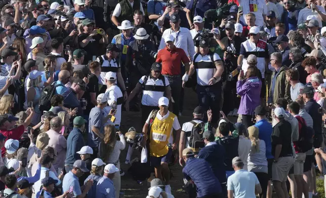 Rory McIlroy of Northern Ireland goes to his ball on the 17th which landed win the crowd during the third round of the British Open golf championship at the Royal Portrush Golf Club, Northern Ireland, Saturday, July 19, 2025. (AP Photo/Jon Super)