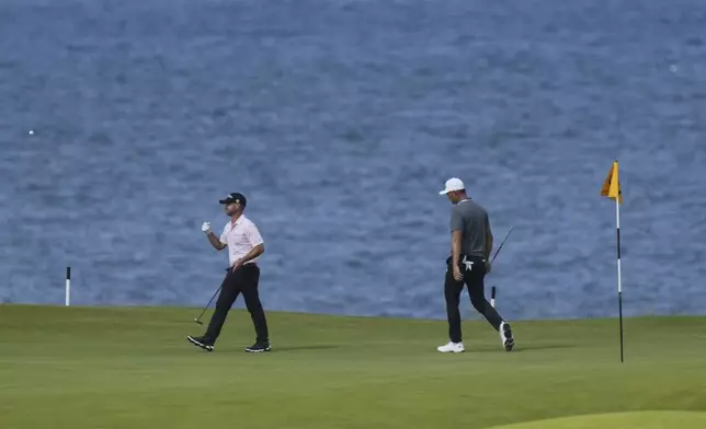 Li Haotong of China, right and Brian Harman of the United States walk on the 5th green during the third round of the British Open golf championship at the Royal Portrush Golf Club, Northern Ireland, Saturday, July 19, 2025. (AP Photo/Jon Super)