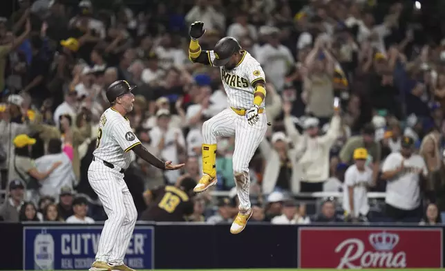 San Diego Padres' Luis Arraez, right, celebrates with third base coach Tim Leiper after hitting a two-run home run during the fifth inning of a baseball game against the New York Mets Monday, July 28, 2025, in San Diego. (AP Photo/Gregory Bull)