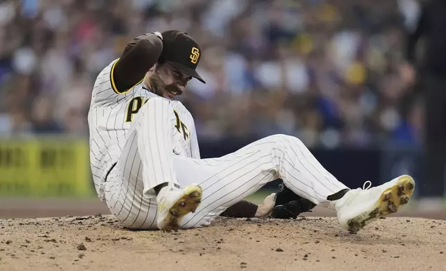 San Diego Padres starting pitcher Dylan Cease, center, reacts after getting hit by a line drive double by New York Mets' Francisco Lindor during the third inning of a baseball game Monday, July 28, 2025, in San Diego. (AP Photo/Gregory Bull)