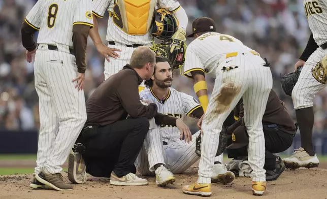 San Diego Padres starting pitcher Dylan Cease, center, reacts after getting hit by a line drive double by New York Mets' Francisco Lindor during the third inning of a baseball game Monday, July 28, 2025, in San Diego. (AP Photo/Gregory Bull)