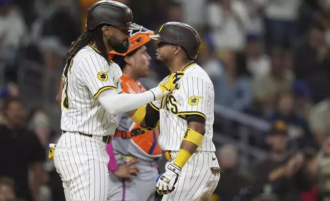 San Diego Padres' Luis Arraez, right, celebrates with teammate Fernando Tatis Jr. after hitting a two-run home run during the fifth inning of a baseball game against the New York Mets Monday, July 28, 2025, in San Diego. (AP Photo/Gregory Bull)
