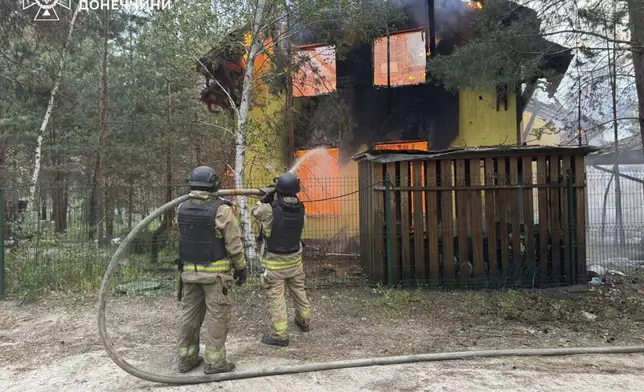 In this photo provided by the Ukrainian Emergency Service, emergency services personnel work to extinguish a fire following a Russian attack in Donetsk region, Ukraine, Wednesday, July 2, 2025. (Ukrainian Emergency Service via AP)