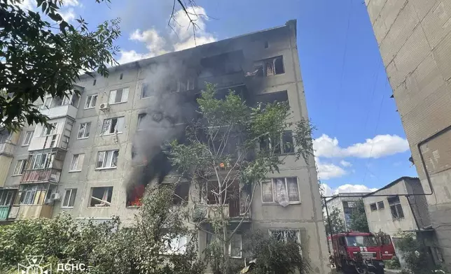 In this photo provided by the Ukrainian Emergency Service, emergency services personnel work to extinguish a fire following a Russian attack in Donetsk region, Ukraine, Wednesday, July 2, 2025. (Ukrainian Emergency Service via AP)