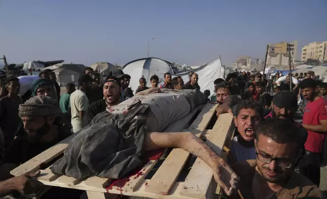 CORRECTS CAUSE OF DEATH Palestinians carry the body of a man who was hit by a truck while attempting to reach a humanitarian aid convoy that entered Gaza City from the northern Gaza Strip, Saturday, July 26, 2025. (AP Photo/Abdel Kareem Hana)