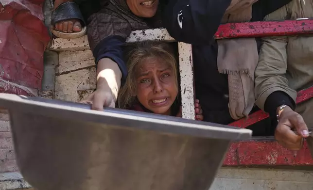 Palestinians struggle to get donated food at a community kitchen, in Gaza City, northern Gaza Strip, Saturday, July 26, 2025. (AP Photo/Abdel Kareem Hana)