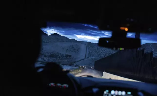 A view from inside a U.S. Border Patrol vehicle shows the U.S.-Mexico border fence at dawn in Sunland Park, N.M., Wednesday, July 23, 2025. (AP Photo/Jae C. Hong)