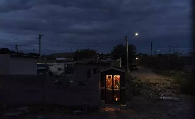 A cartel shrine in Mexico's Ciudad Juárez, symbolizing territorial control, is visible through the U.S.-Mexico border fence from Sunland Park, N.M., Wednesday, July 23, 2025. (AP Photo/Jae C. Hong)