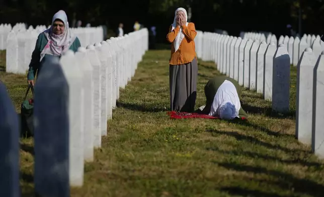 Women pray at the Memorial Center for victims of the Srebrenica genocide in Potocari, Bosnia, Friday, July 11, 2025. (AP Photo/Darko Bandic)