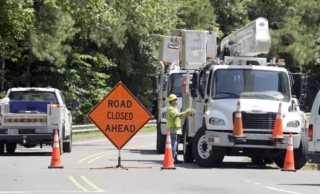 Utility crews work to restore lines that were knocked down on Estes Drive during tropical storm Chantal, Monday, July 7, 2025, in Chapel Hill, N.C. (AP Photo/Chris Seward)