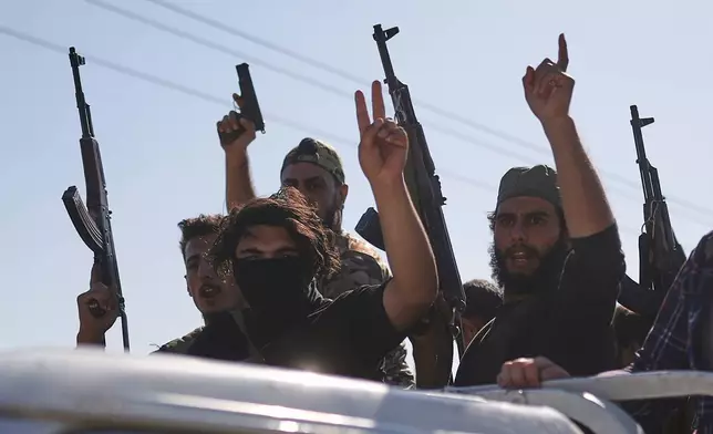 Bedouin fighters stand on a pickup truck as they arrive at al-Dour village on the outskirts of Sweida city, during clashes between the Bedouin clans and Druze militias, southern Syria, Friday, July 18, 2025. (AP Photo/Ghaith Alsayed)