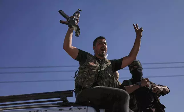 A Bedouin fighter flashes victory sign and shouts slogans at Mazraa village on the outskirts of Sweida city, during clashes between the Bedouin clans and Druze militias, southern Syria, Friday, July 18, 2025. (AP Photo/Ghaith Alsayed)