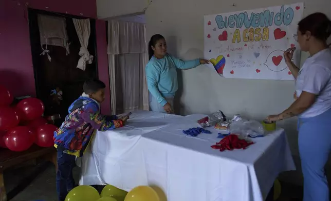 Gabriela Mora, left, decorates her home to welcome her husband Carlos Uzcategui, a Venezuelan migrant deported to El Salvador by the United States, in Lobatera, Venezuela, Monday, July 21, 2025. (AP Photo/Ariana Cubillos)