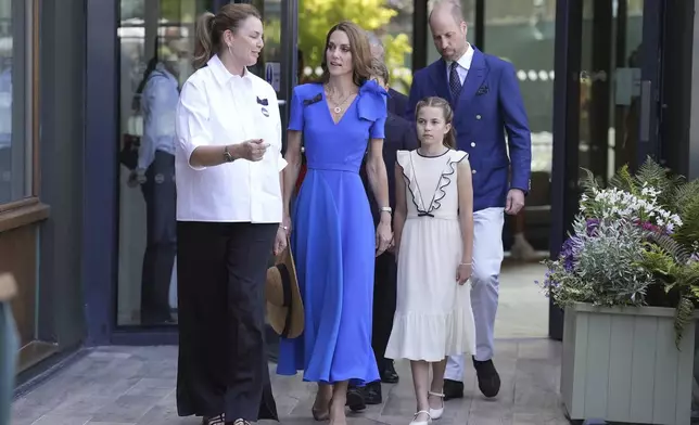 Britain's Prince William, Kate, Princess of Wales, center, and Princess Charlotte are greeted by Sally Ambrose, left, a member of the Committee of Management of The Championships, as they arrive to attend the men's singles final match between Italy's Jannik Sinner and Spain's Carlos Alcaraz at the Wimbledon Tennis Championships in London Sunday July 13, 2025. (Andrew Matthews/Pool via AP)